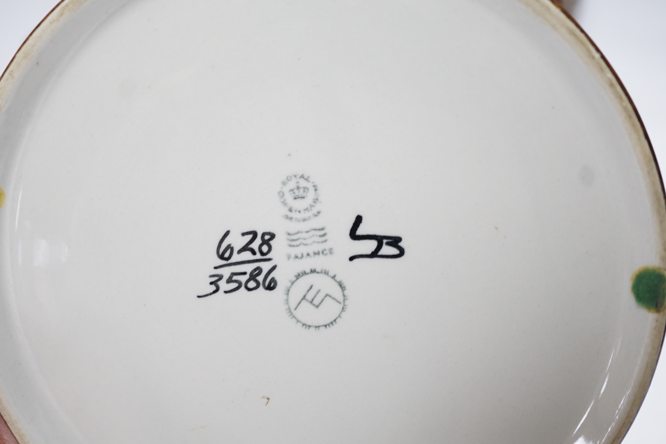 Seven Royal Copenhagen fajance items; a vase decorated with birds, a vase, decorated with fish, a small pot, a holder, two circular dishes and a teapot stand, largest dish 26cm diameter